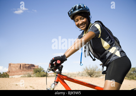 Casque de cycliste avec femelle outdoors smiling Banque D'Images