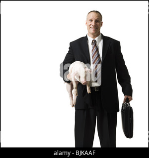 Businessman holding briefcase et Porcinet Banque D'Images