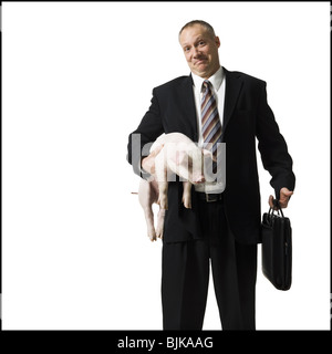 Businessman holding briefcase et Porcinet Banque D'Images