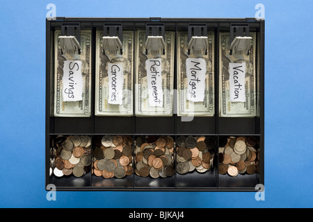 Détail de la devise américaine et des pièces dans le till avec des étiquettes pour les dépenses Banque D'Images