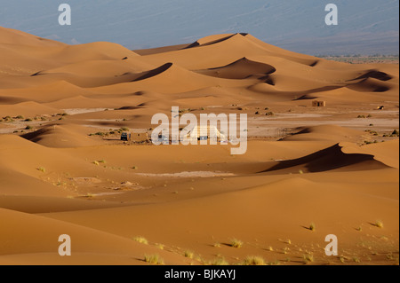 Il s'agit d'une image d'un camp dans le désert au milieu des dunes de sable dans le désert du Sahara Occidental au Maroc. Banque D'Images