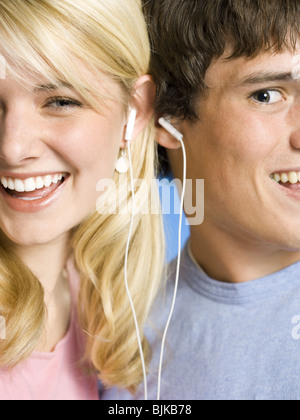 Portrait d'un jeune couple avec les oreillettes smiling