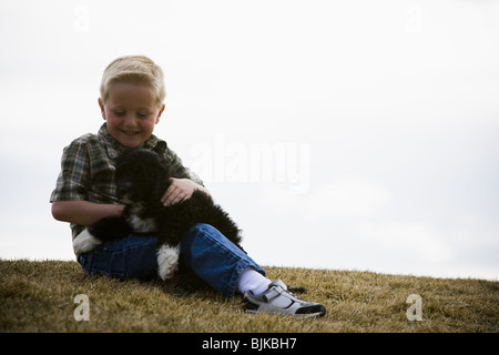 Garçon avec puppy outdoors Banque D'Images