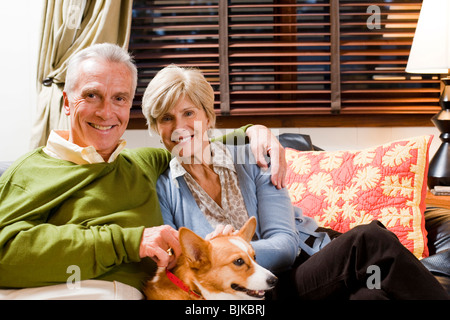 Mature couple on sofa with dog Banque D'Images