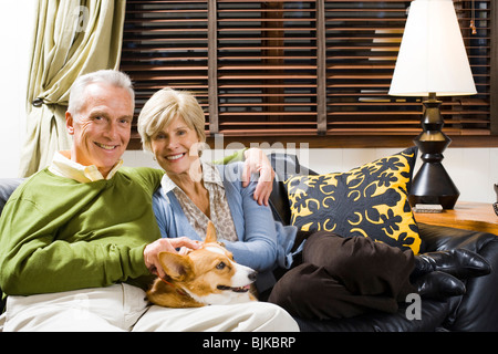 Mature couple on sofa with dog Banque D'Images