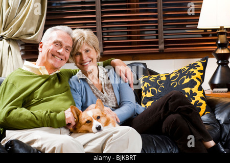 Mature couple on sofa with dog Banque D'Images