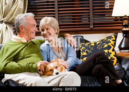 Mature couple on sofa with dog Banque D'Images