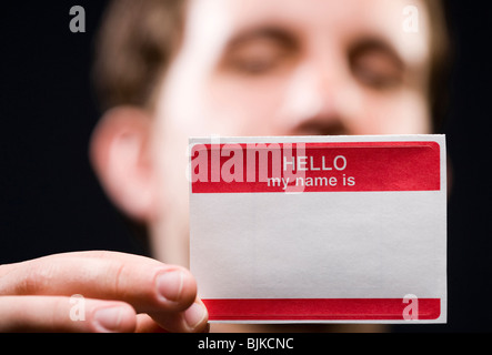 Man holding blank nom tag Banque D'Images