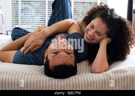 L'homme et la femme sur le lit se pelotonnant Banque D'Images