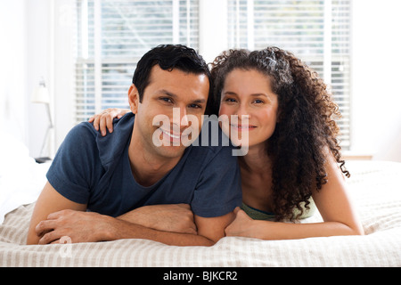 L'homme et la femme sur le lit se pelotonnant Banque D'Images