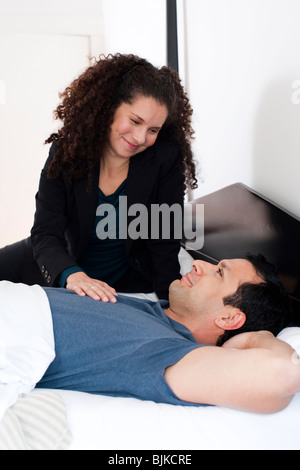 L'homme et la femme sur le lit se pelotonnant Banque D'Images