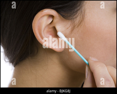 De gros plan femme coton-tige avec de l'oreille Banque D'Images