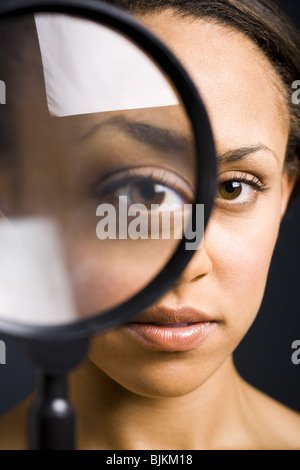 Closeup of woman holding magnifying glass pour les yeux Banque D'Images