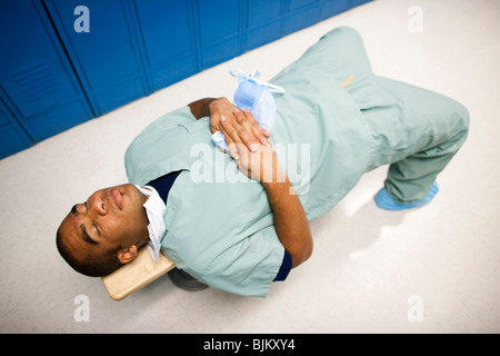 Médecin homme se reposant sur un banc dans scrubs Banque D'Images