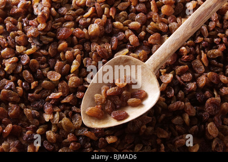 Raisins secs sultanines, Thompson Seedless,, avec une vieille cuillère en bois Banque D'Images