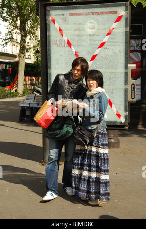 Deux touristes asiatiques trouver leur chemin à Paris France Banque D'Images