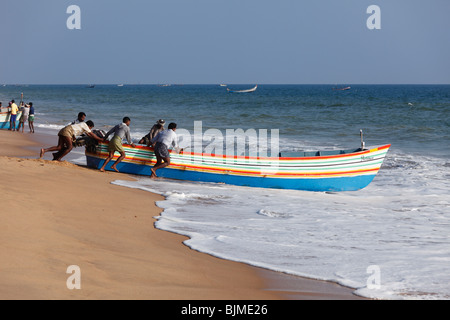 Les pêcheurs poussant leur bateau de pêche dans la mer, plage, Côte d'Malabarian Somatheeram, Malabar, l'état du Kerala, en Inde, en Asie Banque D'Images
