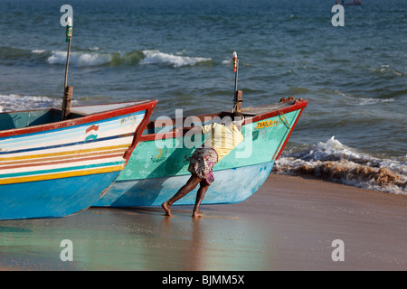 Les pêcheurs poussant leur bateau de pêche dans la mer, plage, Côte d'Malabarian Somatheeram, Malabar, l'état du Kerala, en Inde, en Asie Banque D'Images