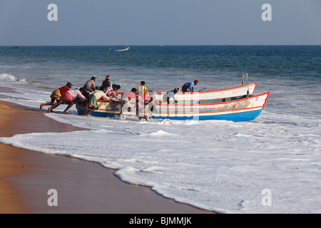 Les pêcheurs poussant leur bateau de pêche dans la mer, plage, Côte d'Malabarian Somatheeram, Malabar, l'état du Kerala, en Inde, en Asie Banque D'Images