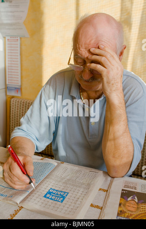 Pensionné résoudre des énigmes dans un magazine Banque D'Images