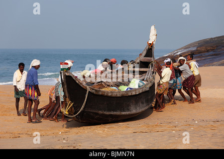 Les pêcheurs tirant leur bateau sur une plage au sud de Kovalam, côte de Malabar, Malabar, Kerala, Inde du Sud, Inde, Asie Banque D'Images