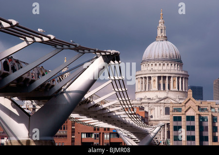 Le Millenium Bridge de Londres avec la pierre blanche de la Cathédrale St Paul en arrière-plan contraste avec un ciel gris foncé Banque D'Images