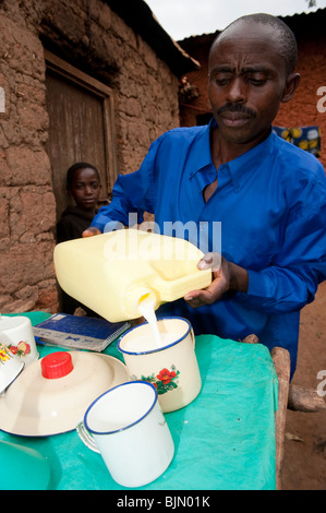 Le remplissage des contenants de lait fermier de vendre. Le Rwanda Banque D'Images