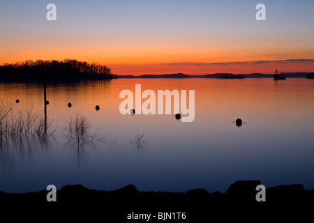 Il s'agit d'un coucher de soleil image prise à l'ancien hôtel du parc fédéral sur la rive est du lac Lanier près de Flowery Branch, ga. la vis à béton dans l'image est utilisée pour fixer l'extrémité d'une chaîne de bouées qui délimitent la zone de baignade. Banque D'Images