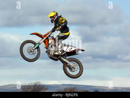 Motocycliste de haut vol dans l'air sur son vélo motocross. Banque D'Images