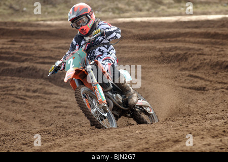 Jeune garçon coureur prend un virage sur son vélo motorcross Banque D'Images