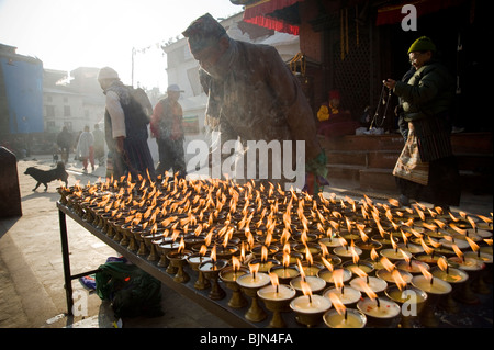 Un homme des bougies d'éclairage extérieur de l'entrée de stupa Boudhanath à Katmandou, Népal Banque D'Images