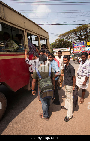 L'Inde, le Kerala, Alappuzha (Alleppey), les jeunes hommes de l'état d'embarquement bus à coin de rue Banque D'Images