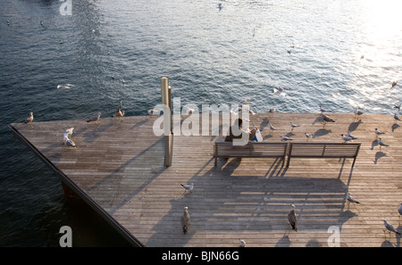 Les goélands d'alimentation de l'homme sur le pont à Port Vell Barcelona Banque D'Images