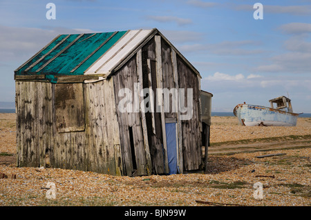 Un ancien en bois délabrées Fishermen's Beach Hut avec voile en arrière-plan. Banque D'Images