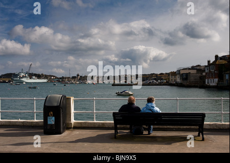 Un couple assis sur un banc dans le port de Falmouth en Cornouailles. Banque D'Images