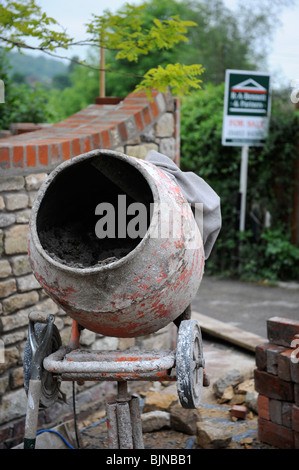 Construction d'un mur de jardin avec un signe suggérant à l'extérieur pour la vente accueil des améliorations pour augmenter la valeur de votre maison UK Banque D'Images