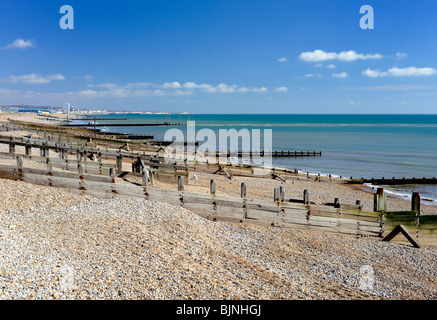 Épis sur la plage de galets à Shoreham à Brighton dans la distance. Banque D'Images