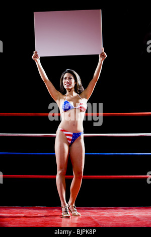 Modèle avec un panneau dans un ring de boxe Banque D'Images