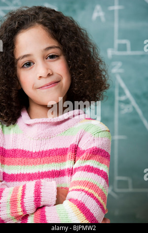 Girl posing in front of chalkboard Banque D'Images