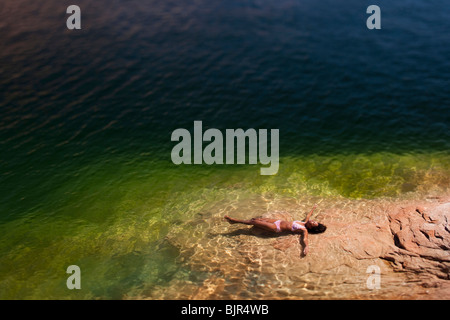 Femme couchée dans l'eau à l'arrière Banque D'Images