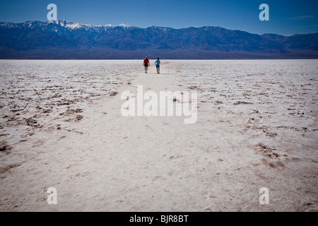 Les touristes se tenir sur les dépôts de sel séché au bassin de Badwater, le point le plus bas sur terre dans Death Valley National Park, Nevada, États-Unis Banque D'Images