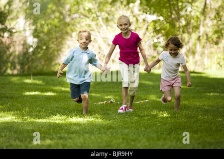 Trois enfants running in park Banque D'Images