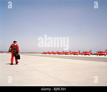 Le chef d'escadron Jean vert des flèches rouges sort seul de son avion, avec certains des autres jets sur la masse. Banque D'Images