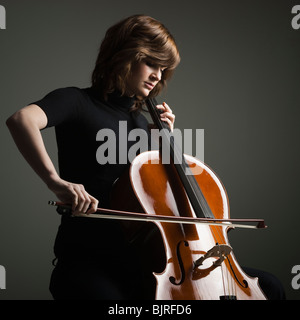 Jeune femme jouant du violoncelle, studio shot Banque D'Images