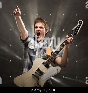 Jeune homme jouant de la guitare basse, studio shot Banque D'Images