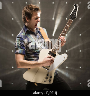 Jeune homme jouant de la guitare basse, studio shot Banque D'Images