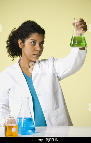 Female scientist looking at produits chimiques dans un laboratoire Banque D'Images