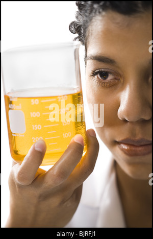 Female scientist looking at produits chimiques dans un laboratoire Banque D'Images