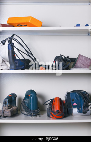 Divers outils d'alimentation potable line les étagères de l'armoire dans un atelier. Banque D'Images