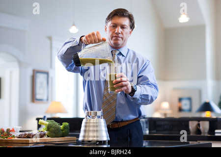 USA, Utah, Alpine, mature man pouring boisson végétale de pitcher au verre Banque D'Images